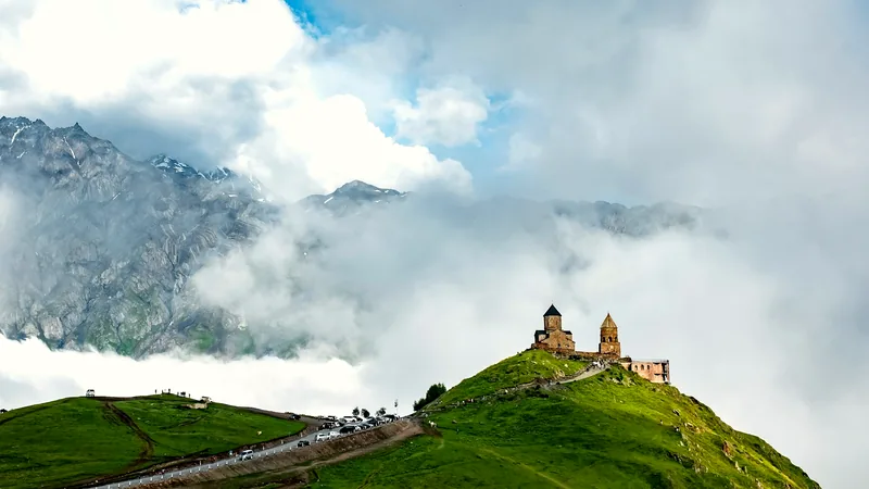 Gergeti Trinity Church on a green ridge below the Caucasus, Georgia