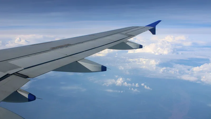 An aircraft wing above the clouds