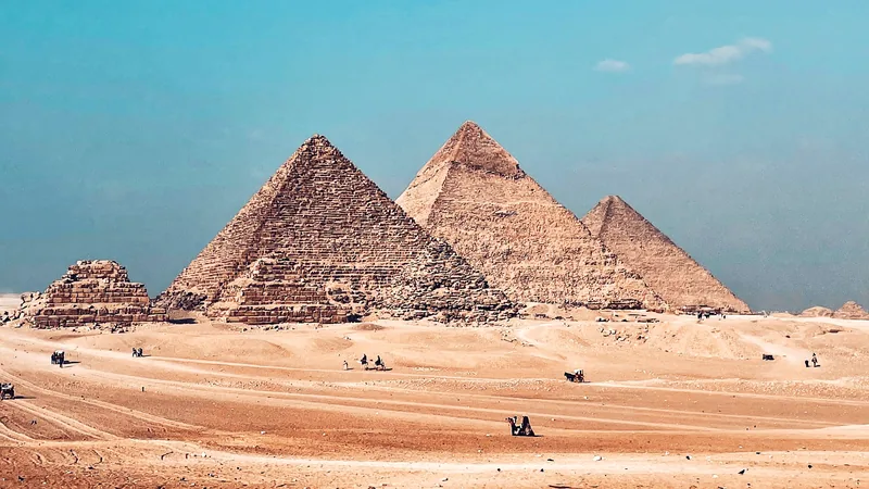The three pyramids of Giza standing above the desert under a clear sky