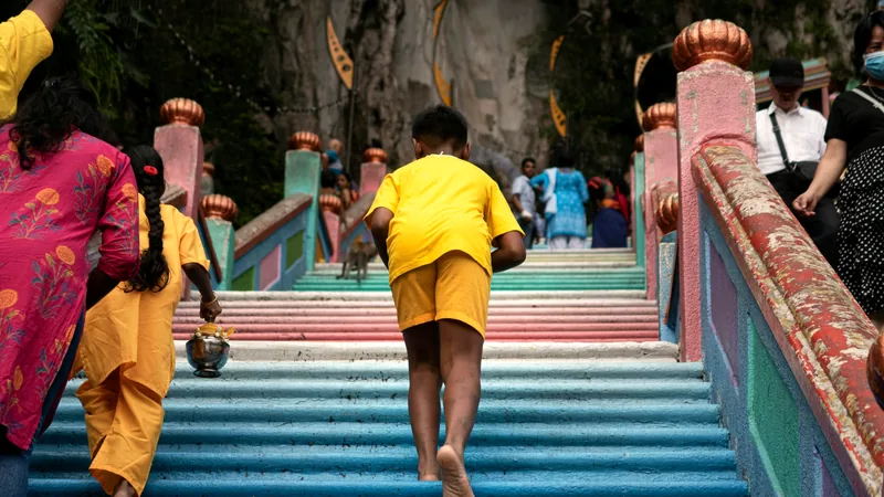Visitors climbing the rainbow-painted staircase at Batu Caves