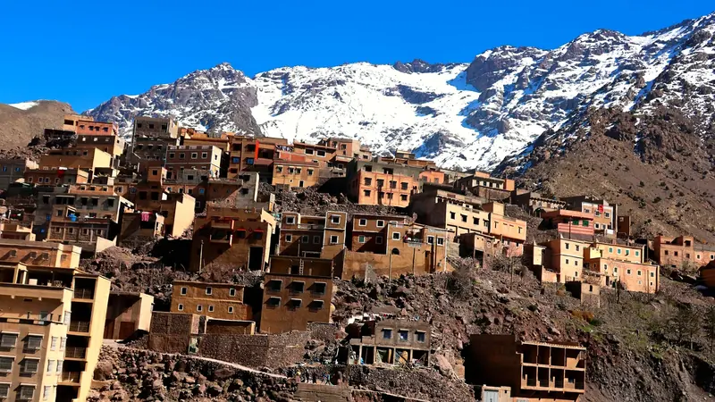 A Berber village below the snow-capped peaks of the Atlas Mountains