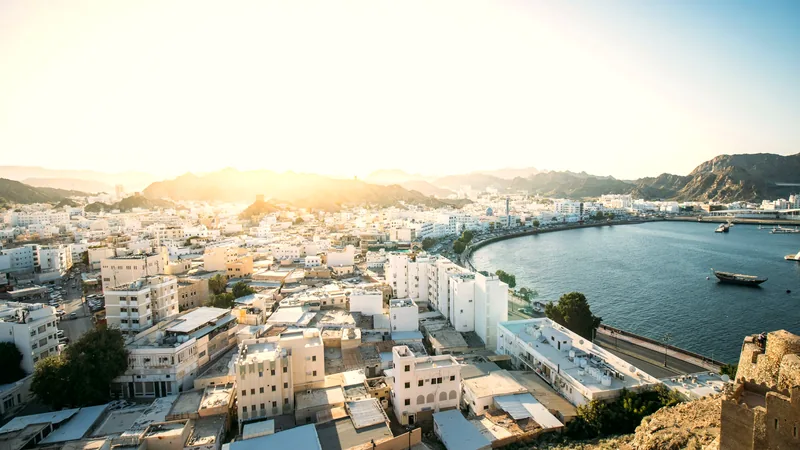 The white town of Mutrah curving around its harbour beneath bare hills