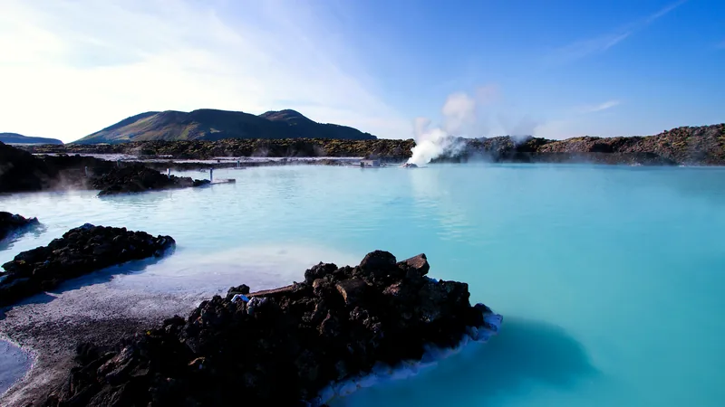 Milky blue geothermal water among black lava rocks at the Blue Lagoon