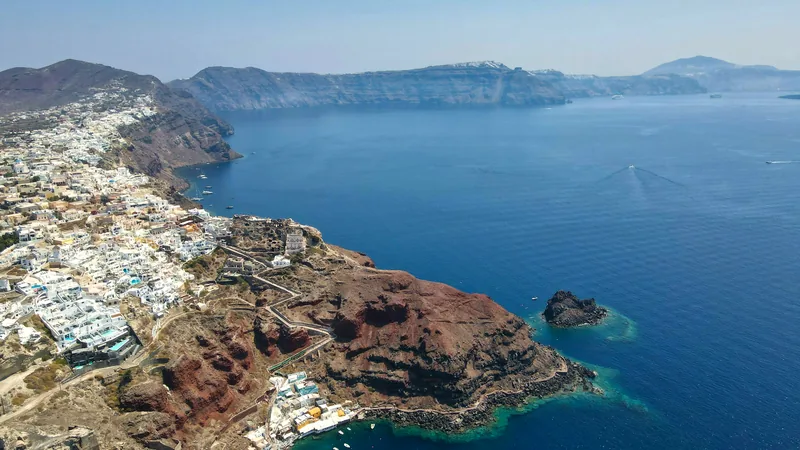 White villages clinging to the red caldera cliffs above deep blue water